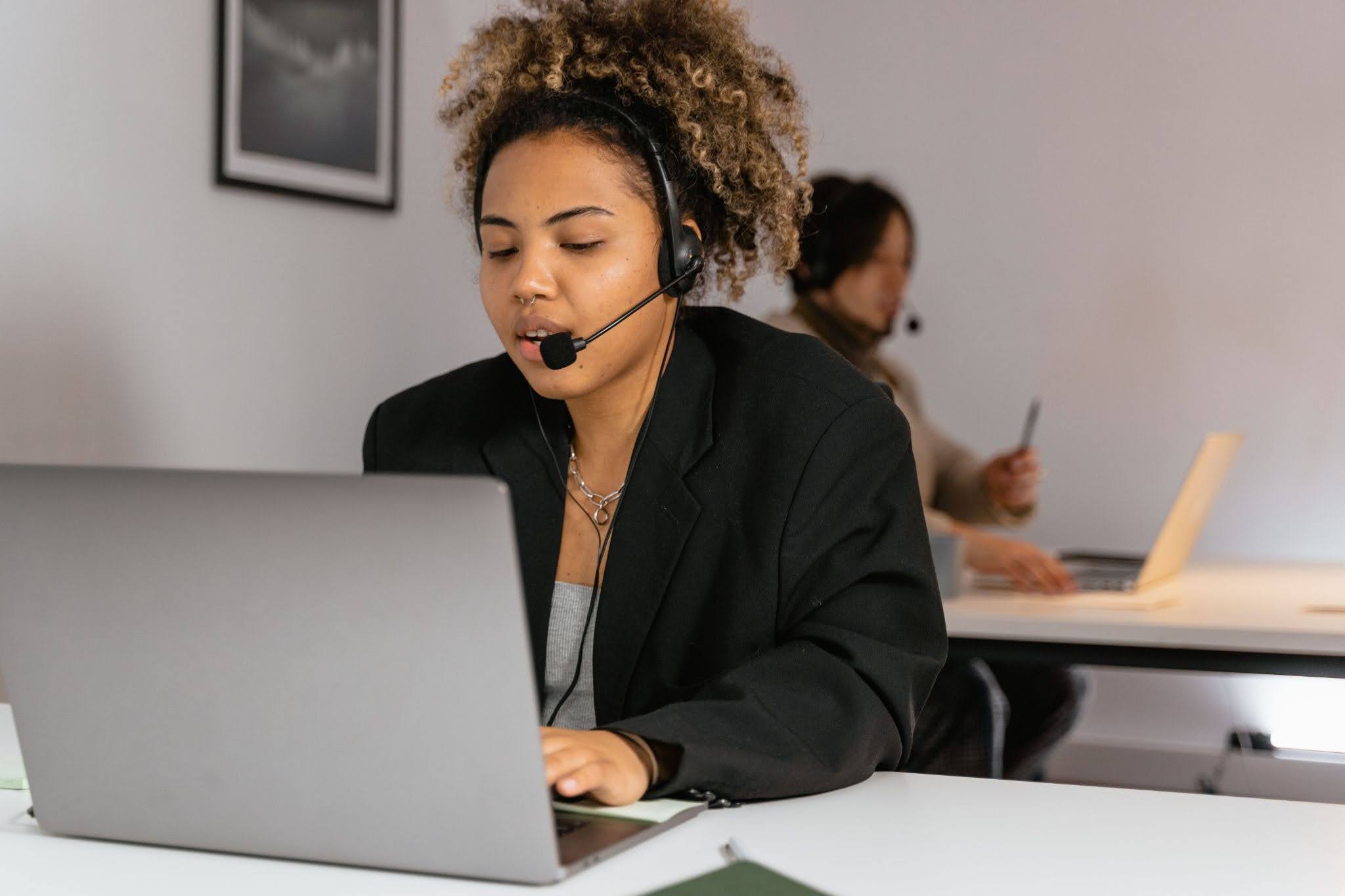 Inbound call center agent handling a customer call at a workstation.