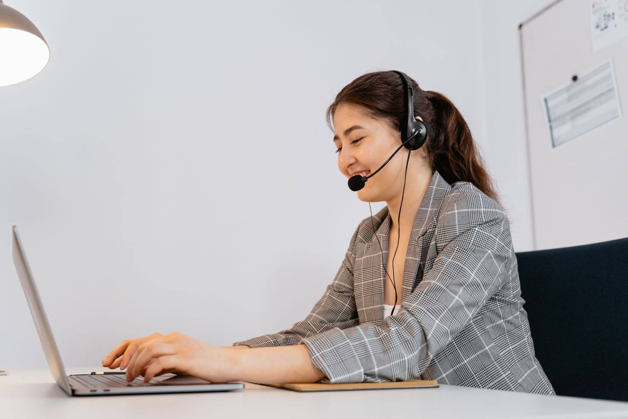  Virtual answering service agent handling customer calls on a laptop.