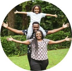 Family photo outdoors - dad has his child on his shoulders.