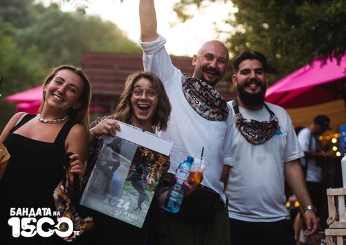 Група младежи от две девойки и две момчета позират за обща снимка. Една от девойките държи календара на Бандата, а единият младеж е вдигнал ръката си нагоре.