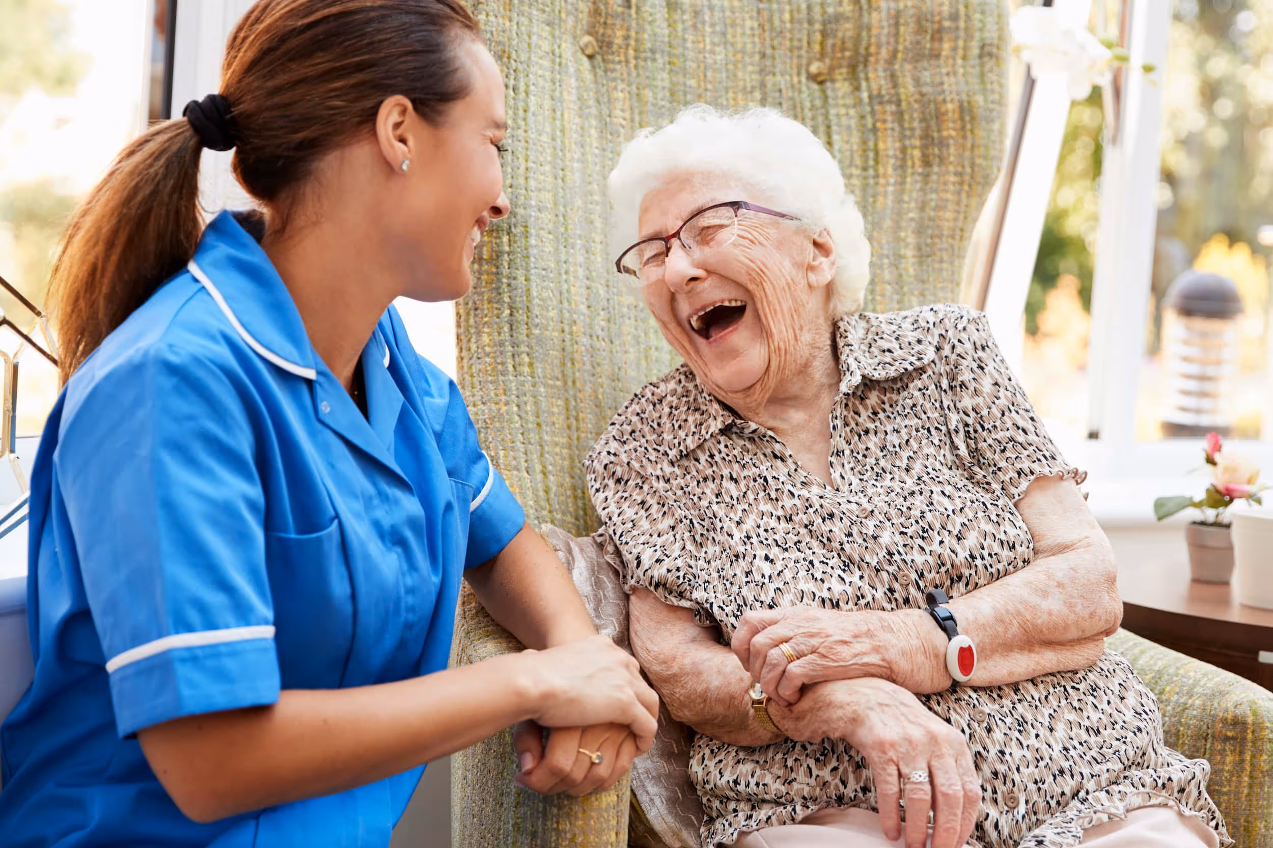 female nursing home nurse making a resident laugh
