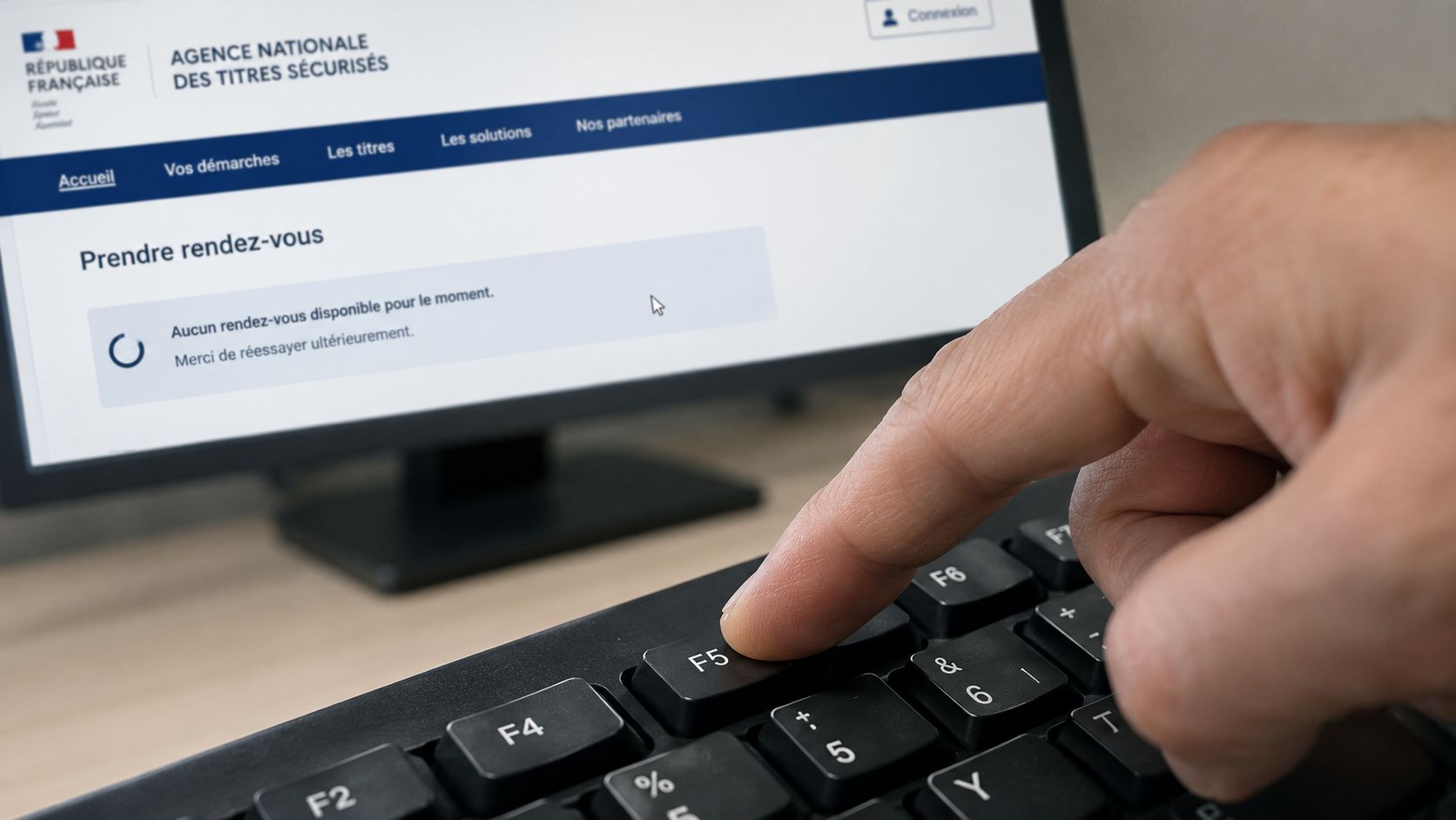 Une personne appuie sur la touche F5 de son clavier pour actualiser la page de prise de rendez-vous.