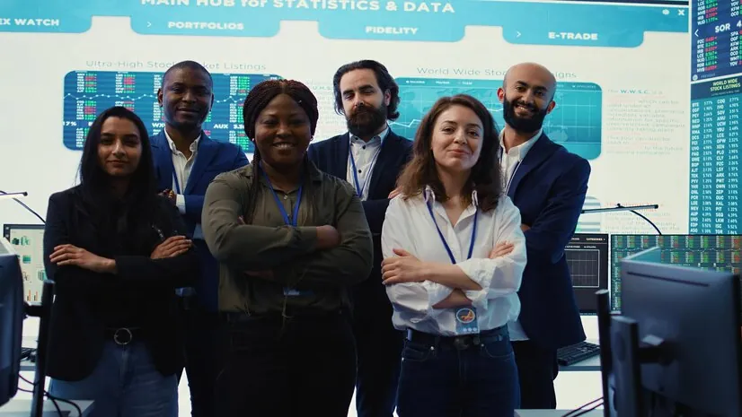 Equipe posando em frente a painéis de dados