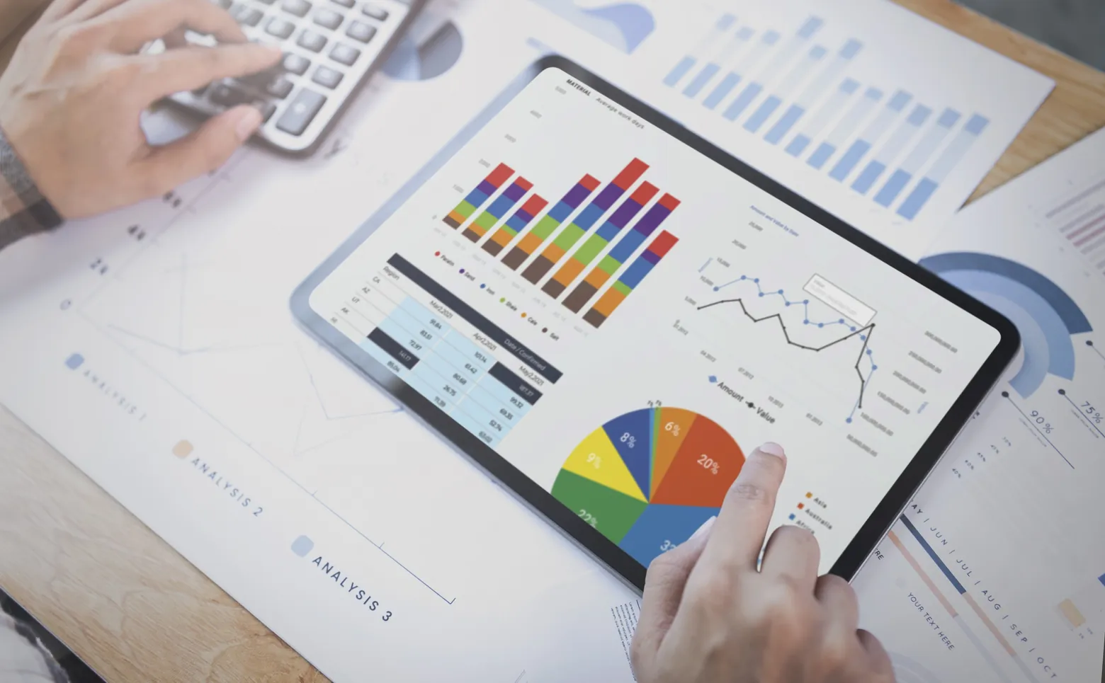 Tablet com gráficos de indicadores sobre relatórios impressos