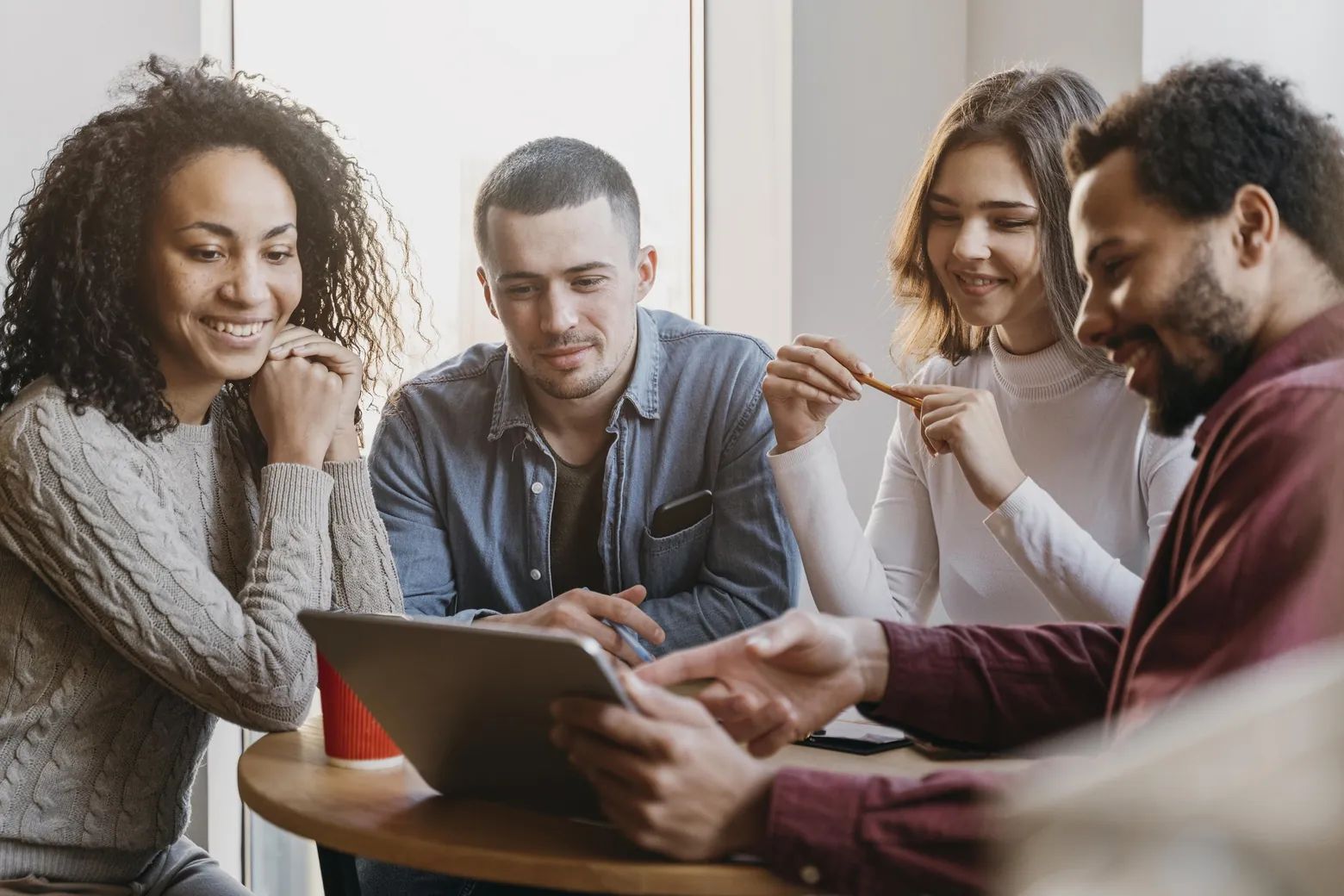 Equipe de RH conversando em volta de um tablet