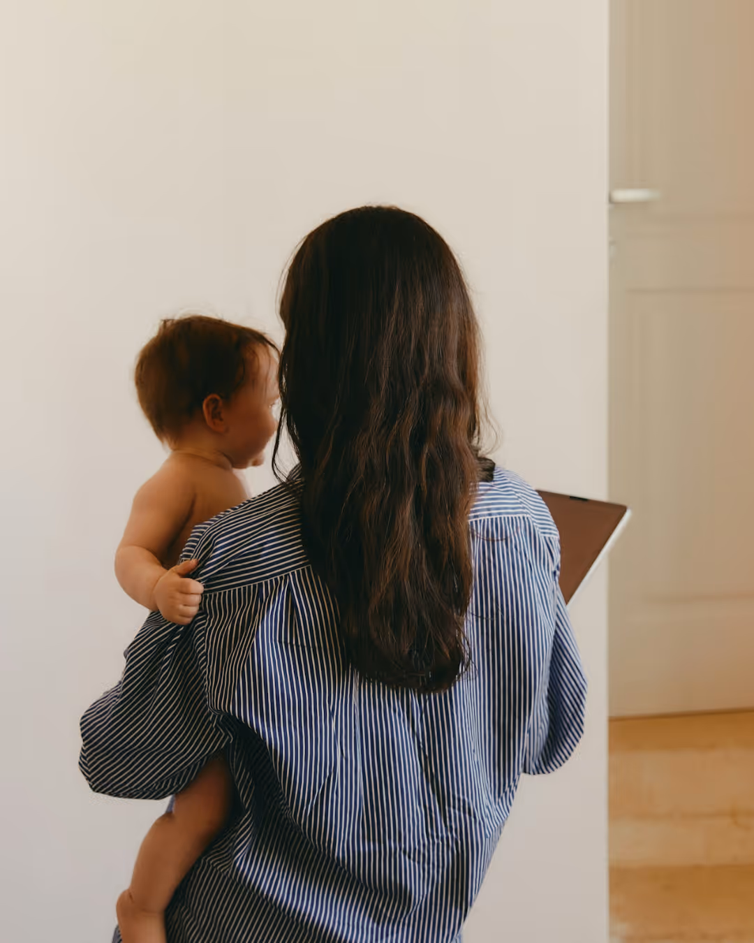 Woman caring for baby holding a device