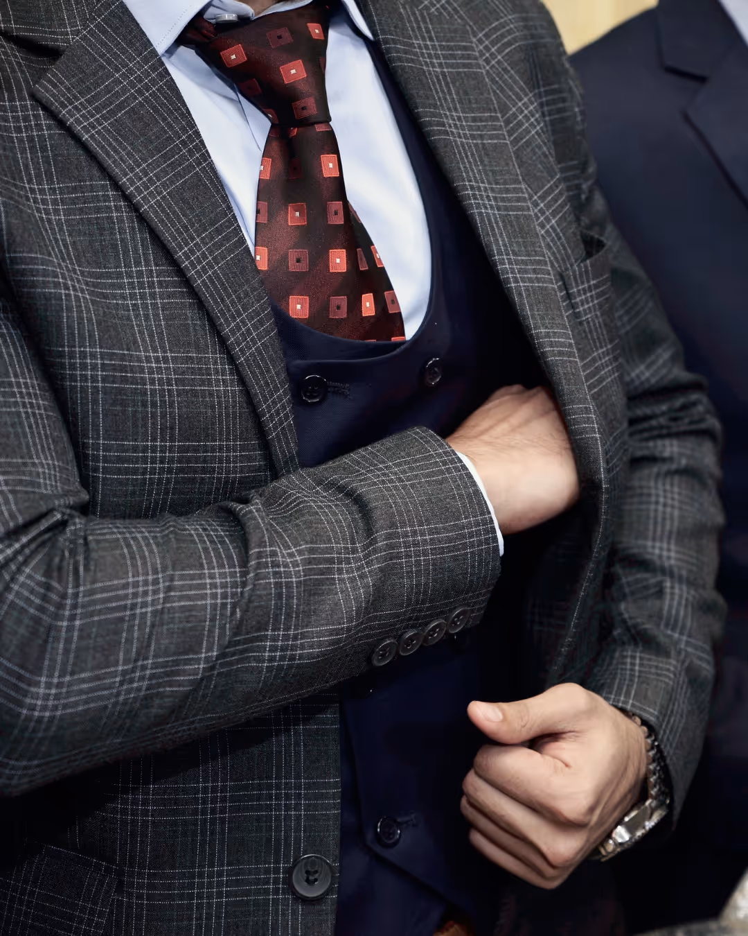 Man in suit reaching into his jacket pocket