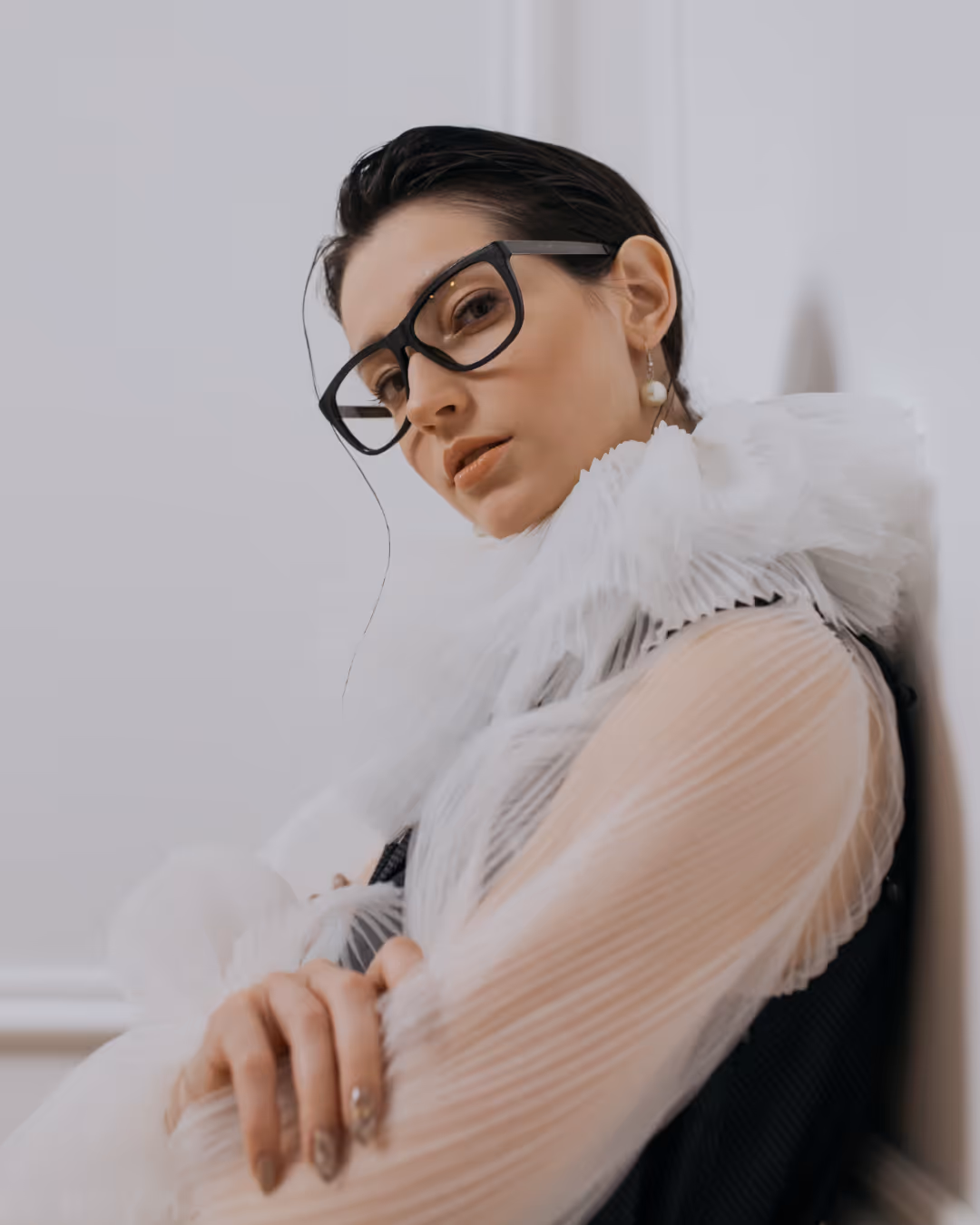 woman in a button down working on laptop in her lap