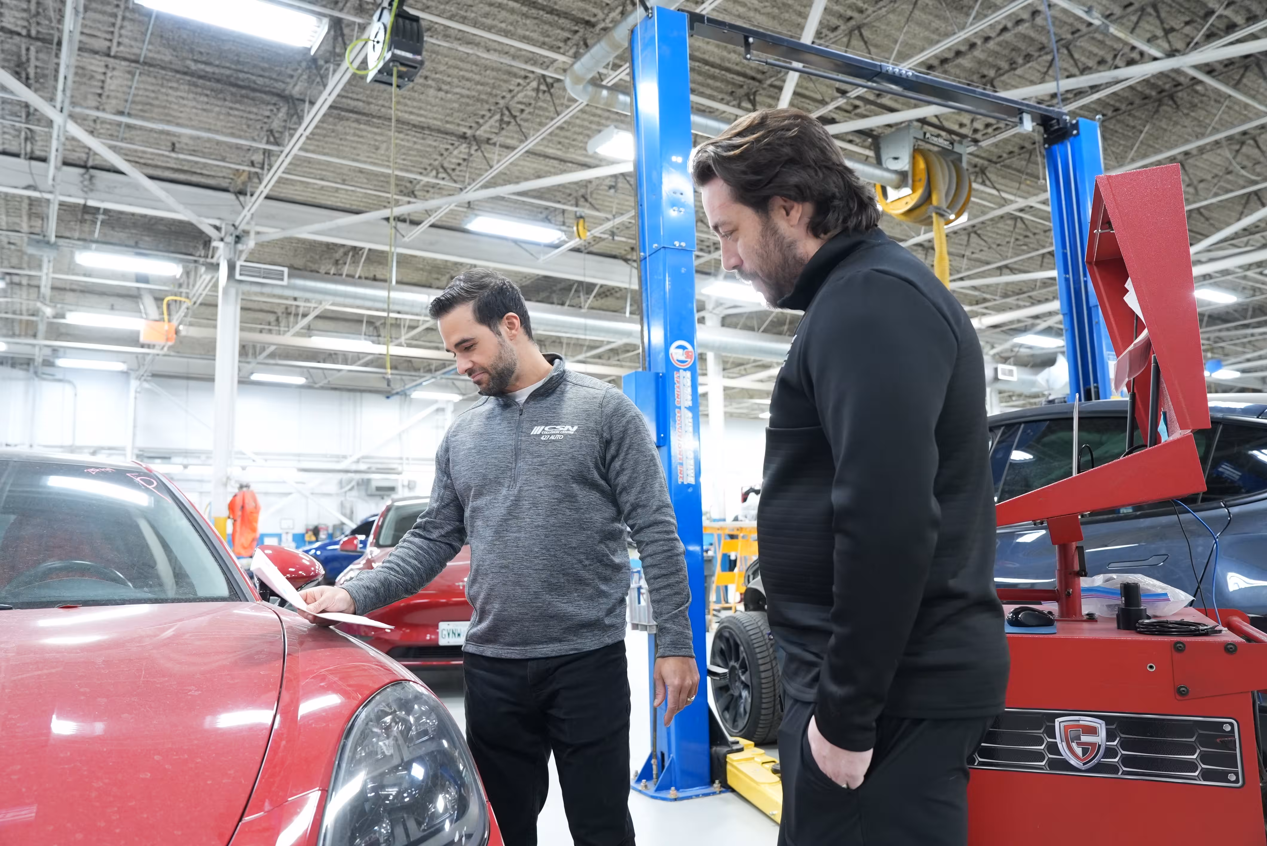 Mechanic working on a car inside a collision repair shop