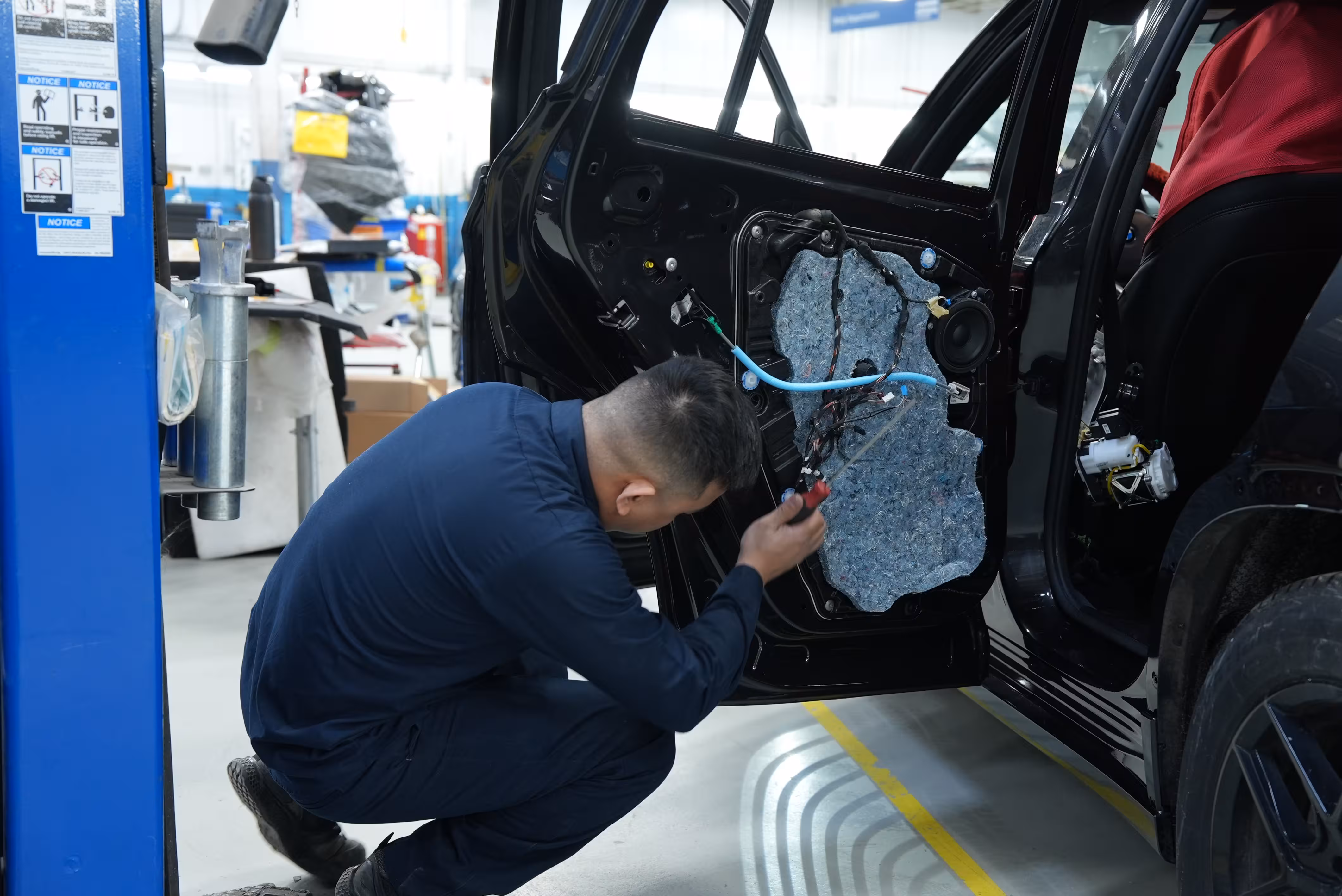 Mechanic working on a car inside a collision repair shop