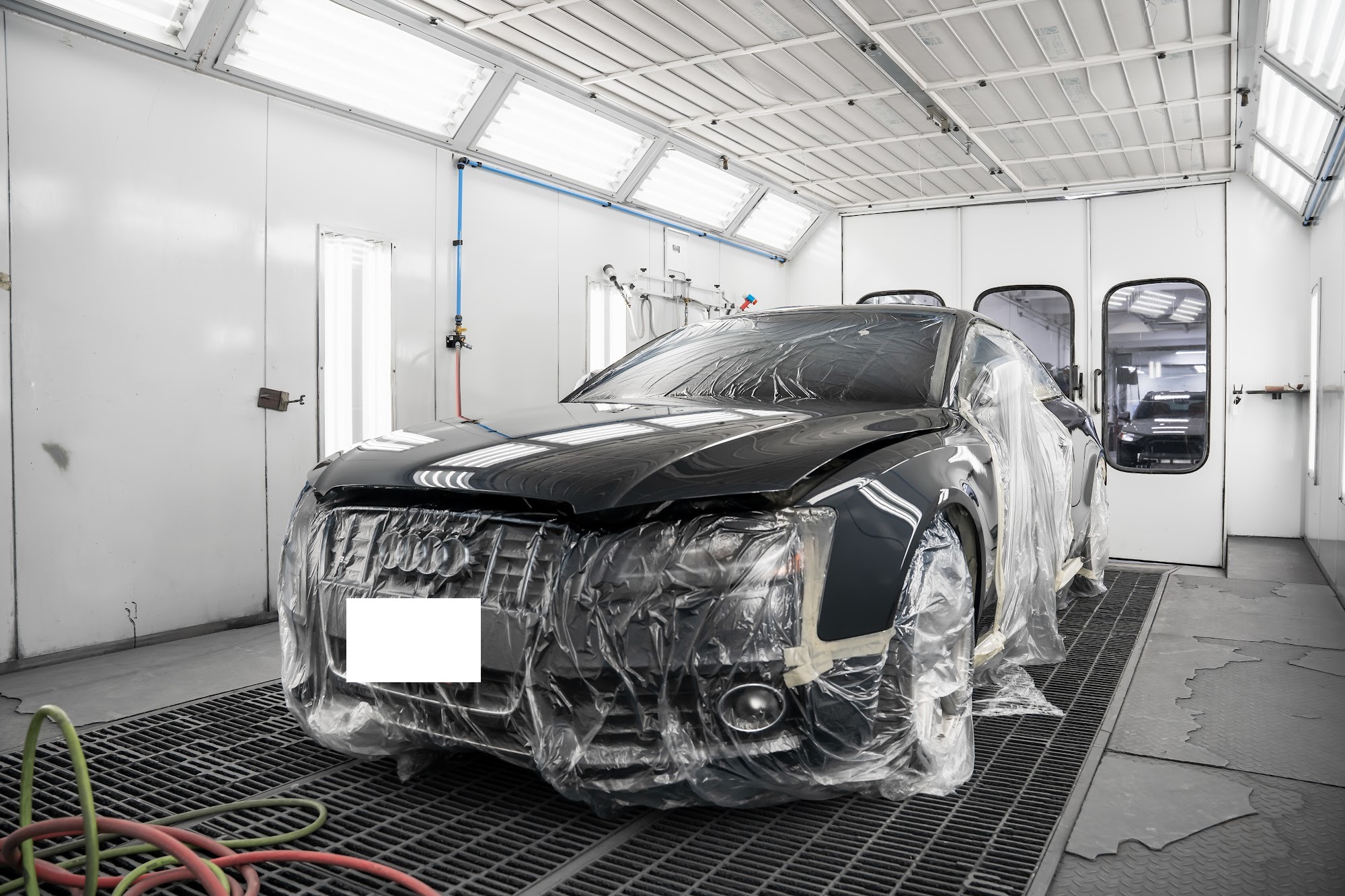 Black Audi masked for paint inside a spray booth at a CSN collision centre