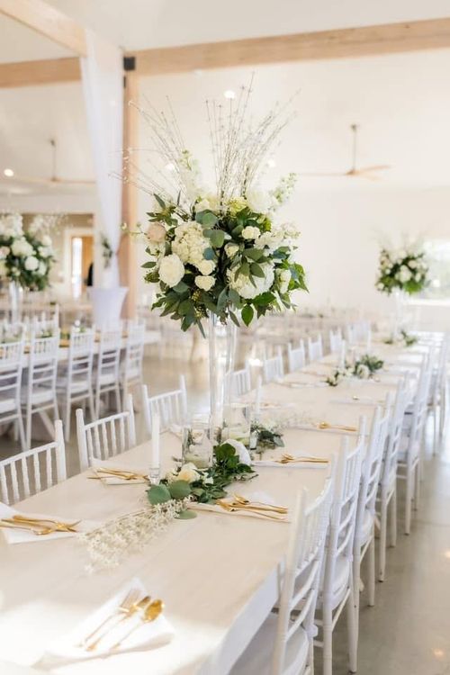 A beautiful and elegant dining setup for a fine dining catered experience in the reception hall of wolf hill venue with a pleasing aesthetic.