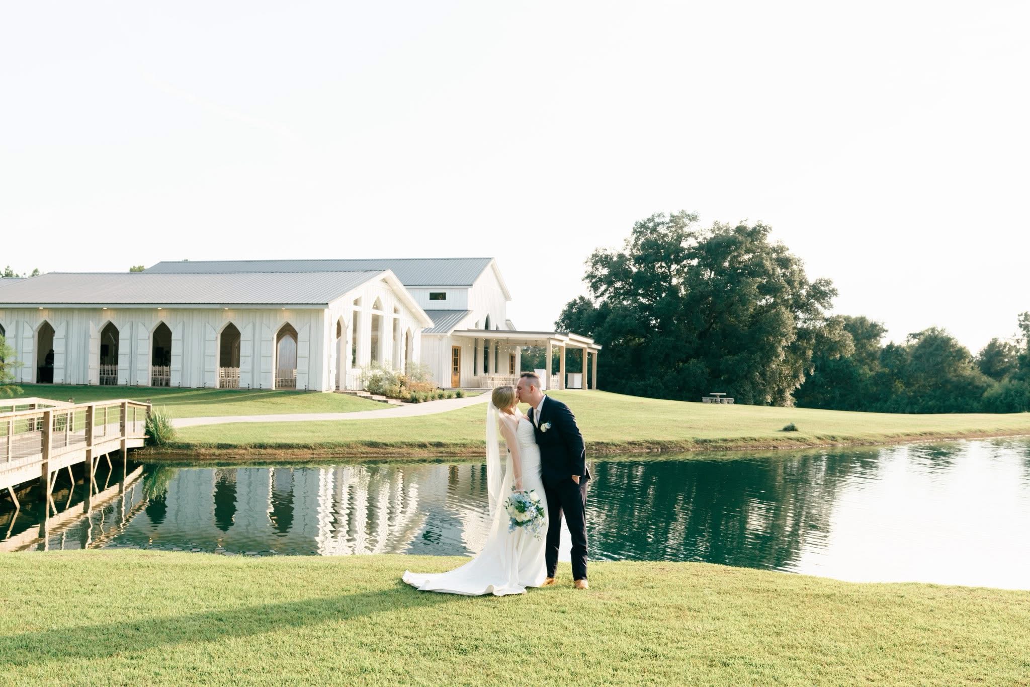 A couple after an engagement and soon to be married taking a moment of reflection and love near the wolf hill wedding venue water front in front of the modern southern style open air chapel and event venue space, near the sunset peninsula. All very elegant, beautiful, and timeless.