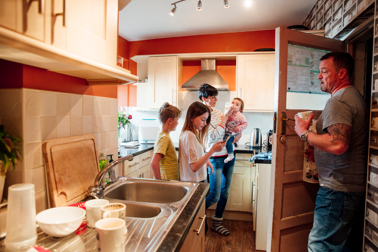 A family in the kitchen of a home with a poorly designed and very cramped kitchen layout