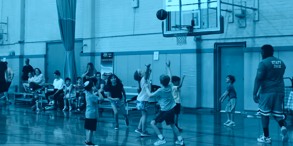 Kids playing basketball at a local gym.
