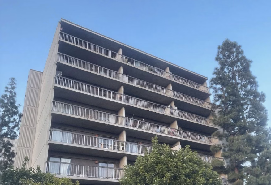 Modern residential building with balconies, surrounded by trees. History Jewish Community Center Westside JCC now J Los Angeles.
