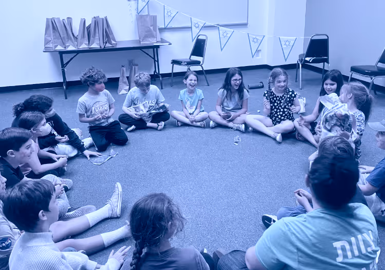 Children gathered in a circle during an activity at the Jewish Community Center.