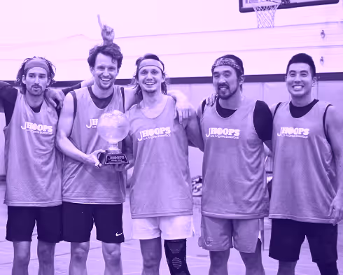 Basketball team celebrating victory at JB Hoops event.