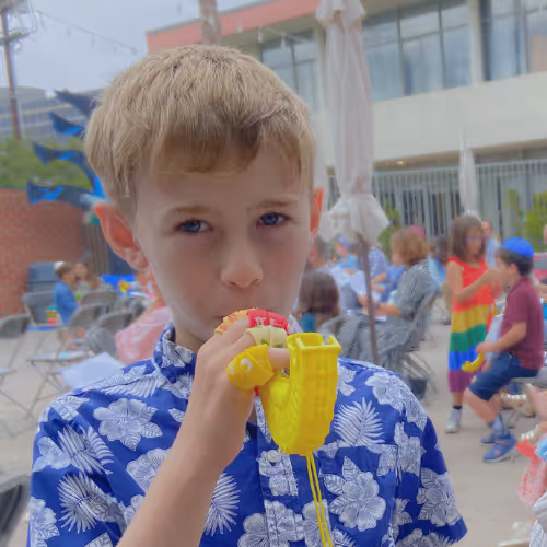 Children enjoying colorful drinks at an outdoor event.