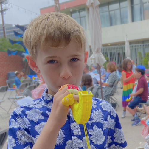 Children enjoying colorful drinks at an outdoor event.