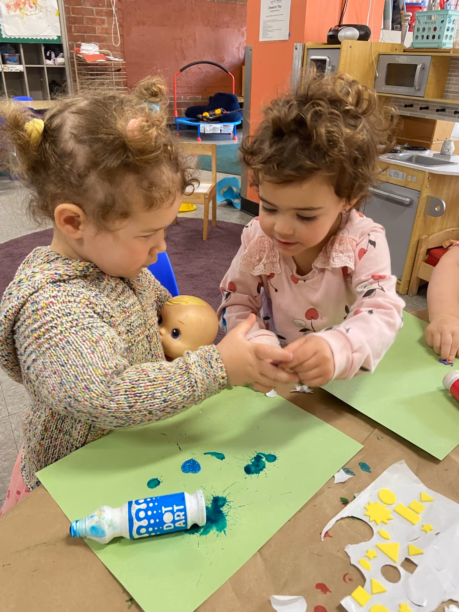 Two young children crafting with paint and paper.
