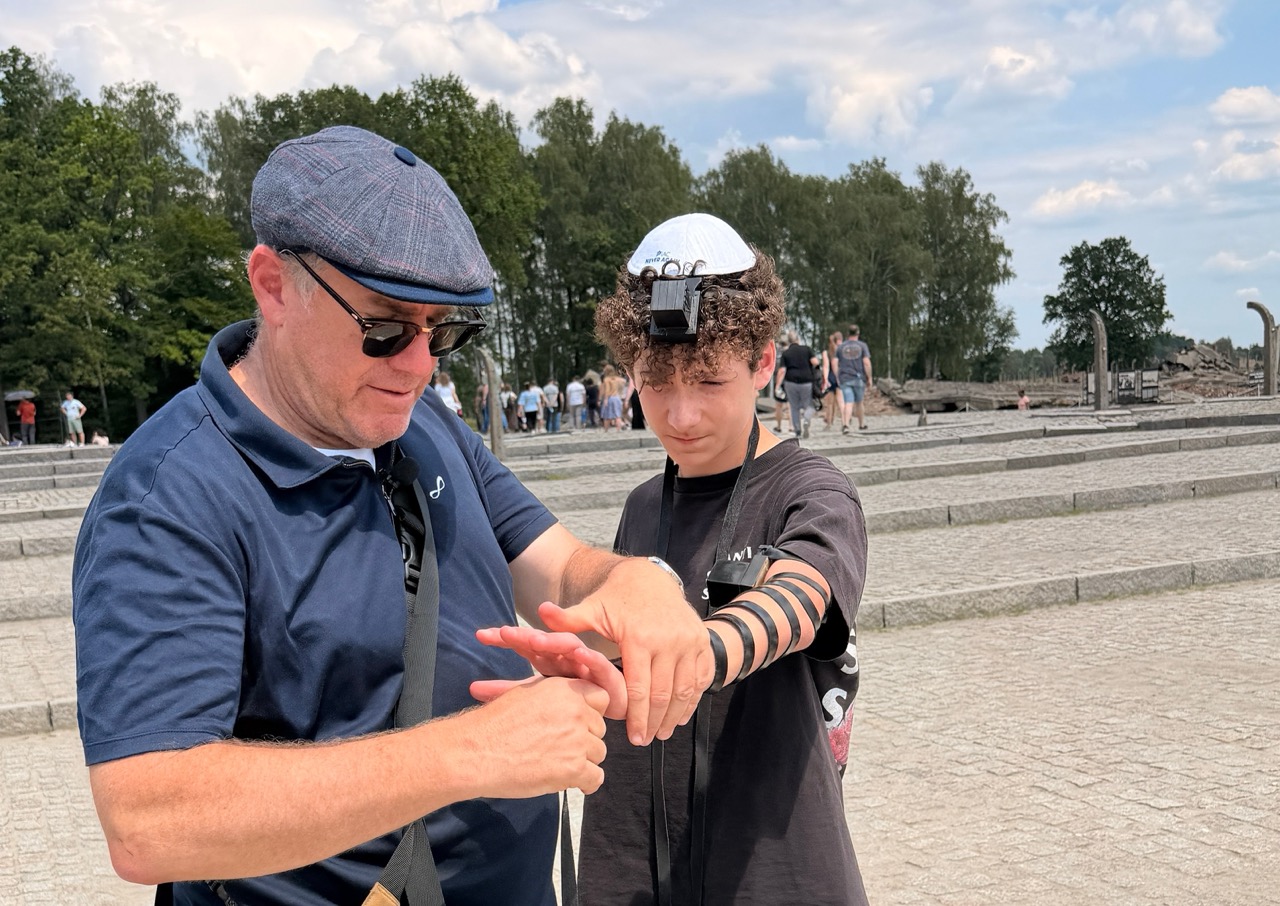 Adam wrapping tefillin at Birkenau
