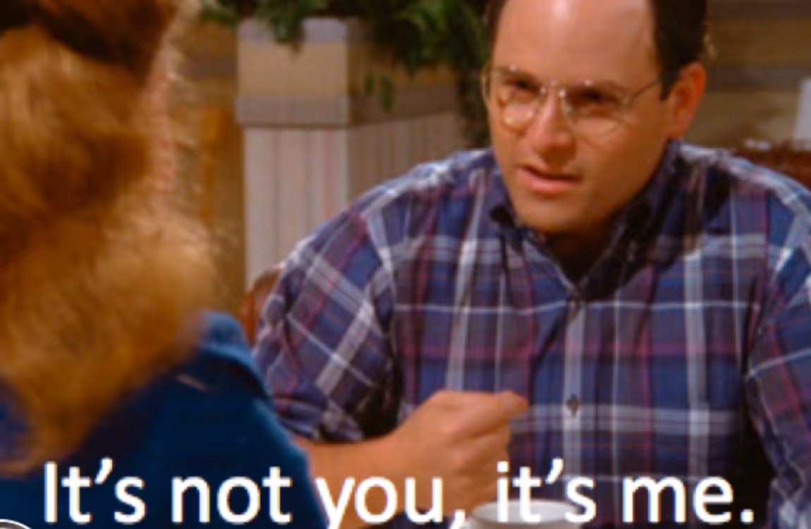 George Costanza from Seinfeld in a plaid shirt, sitting at a table, saying “It’s not you, it’s me.”