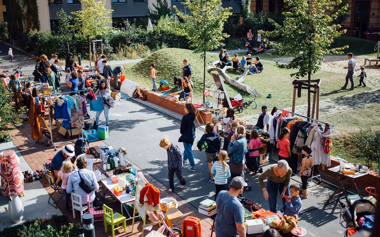 A fleamarket in a park on a sunny day.