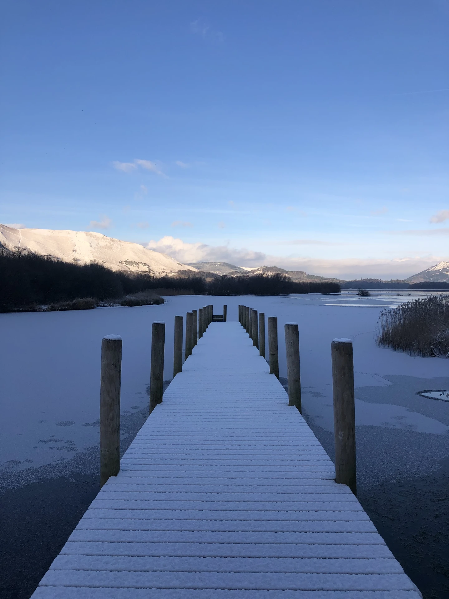 Picturesque image of a small boardwalk going out across the Northern Lakes in the Lake District
