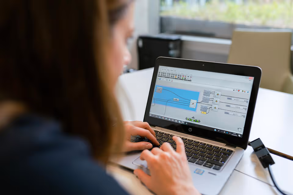 Female engineer looking at laptop screen displaying a simulation setup