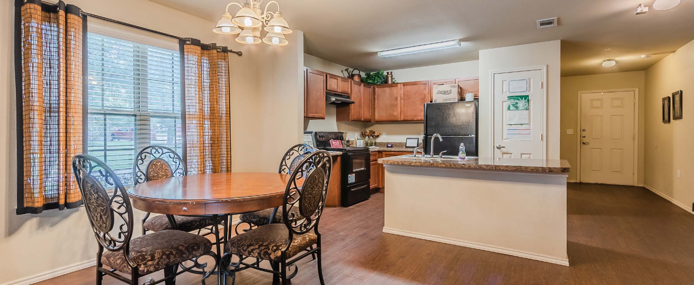 Dining area with table and kitchen with black appliances