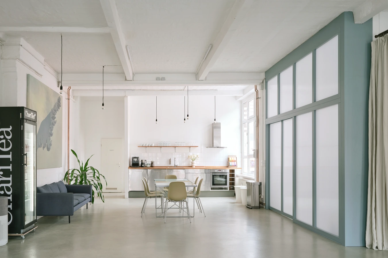 Area delimited with white curtains contains equipment such as polyboards, ladder, extension cables, sandbags and ventilators.
