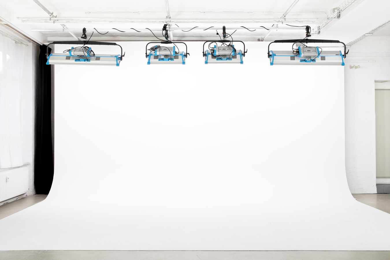 Studio 4 mit weißer Hohlkehle, deckenmontierten ARRI SkyPanel-Leuchten und seitlich gezogenem schwarzem Vorhang für Black-Box-Setup