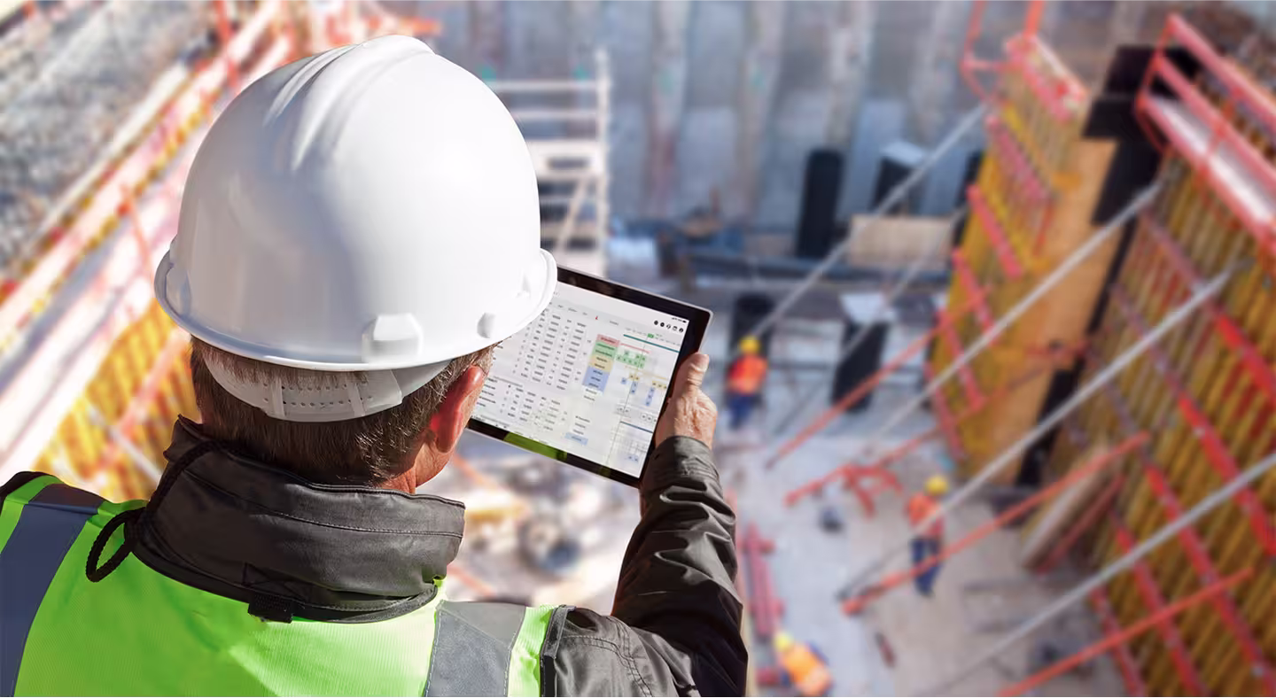 A project manager and superintendent discussing progress on the upper floor of a building under construction.