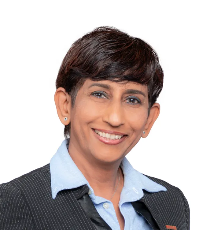 Smiling woman with short dark hair wearing a blue collared shirt and dark pinstripe blazer.