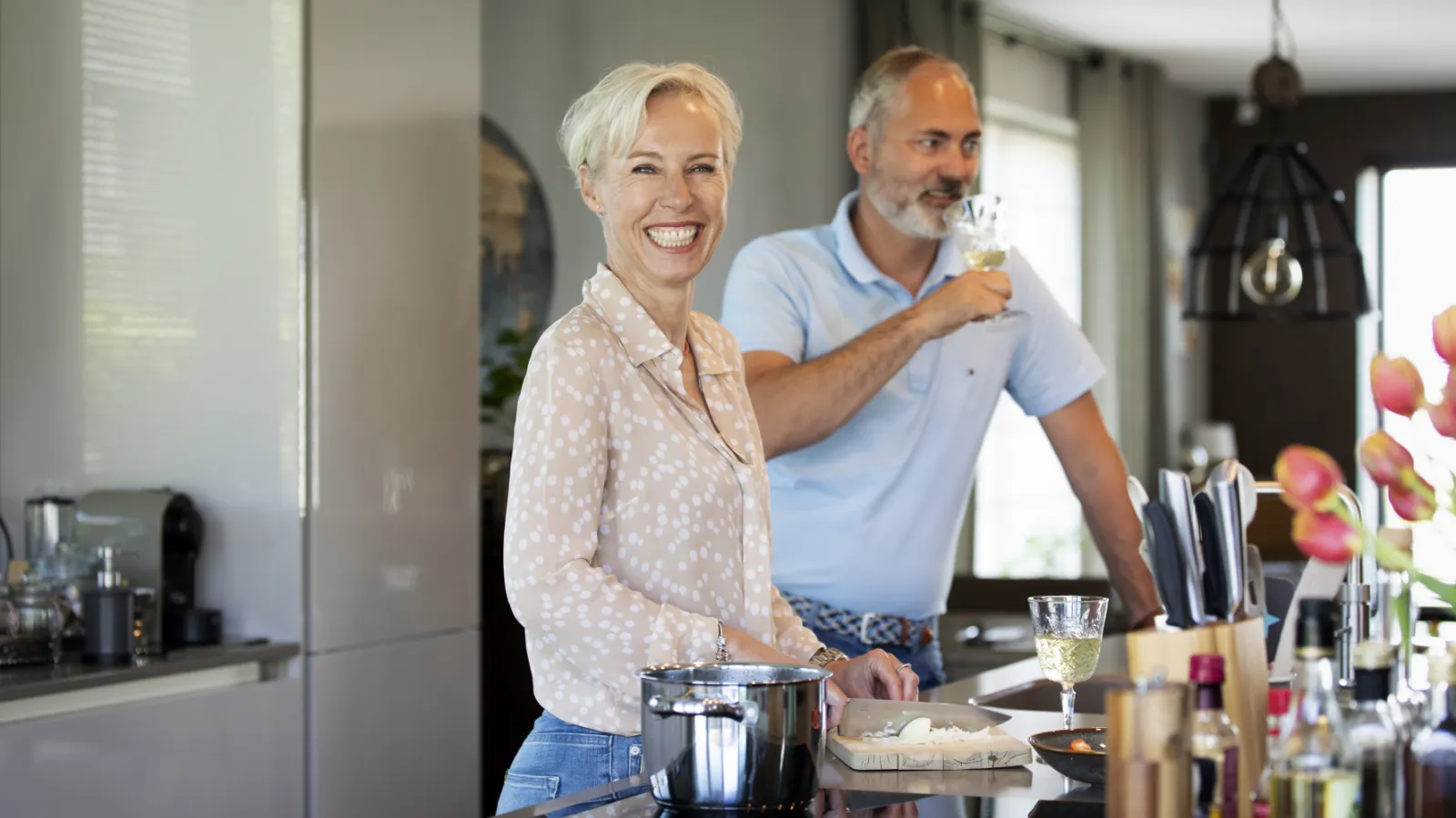 Twee volwassenen staan aan het aanrecht van hun keuken