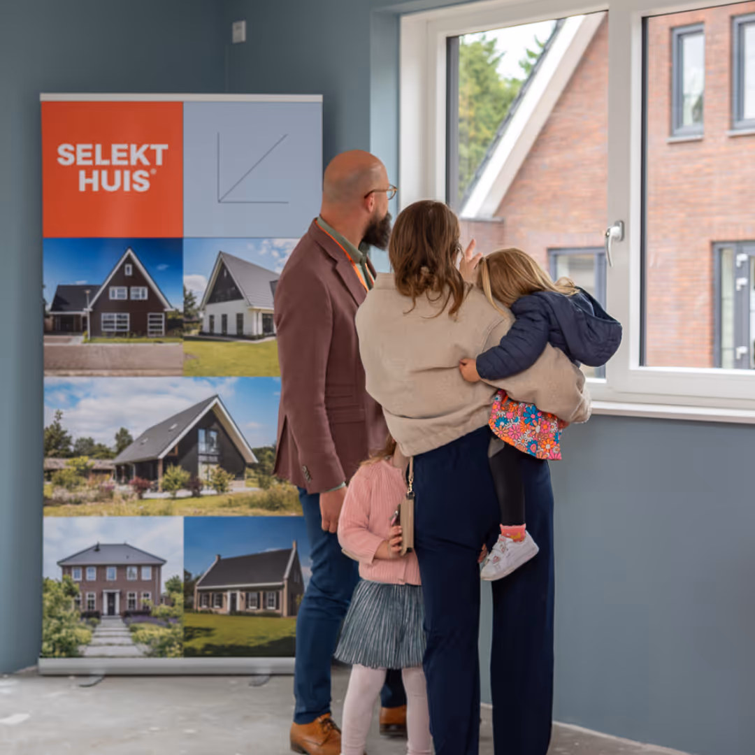 Een gezin staat voor het raam in een woning
