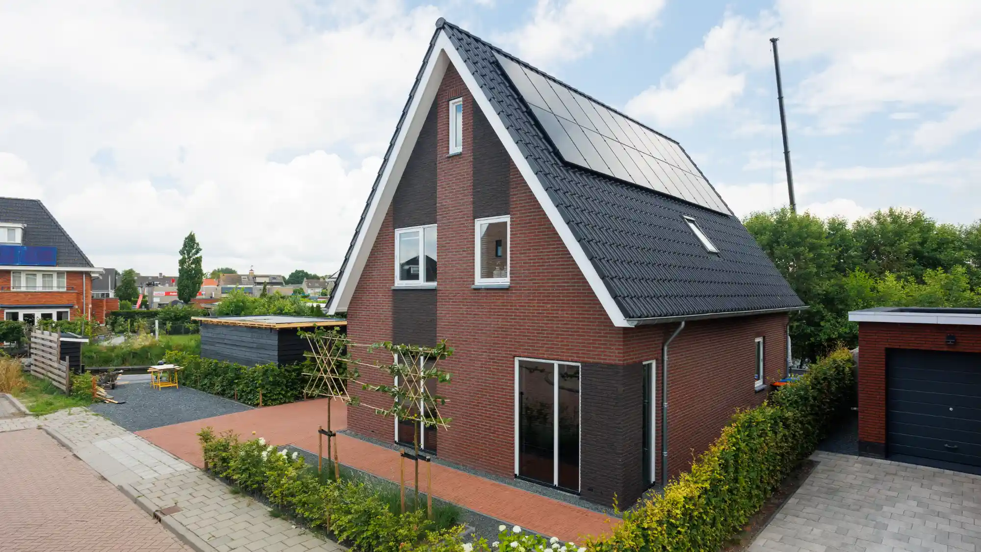 Vrijstaande woning met rode stenen en zonnepanelen op het dak