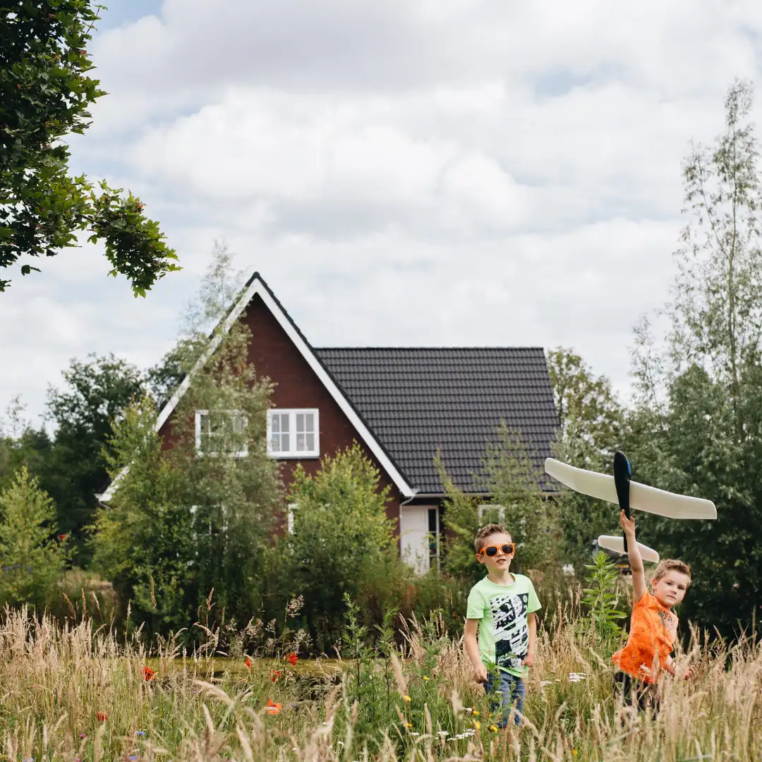 Twee jongens spelen buiten met een vliegtuigje