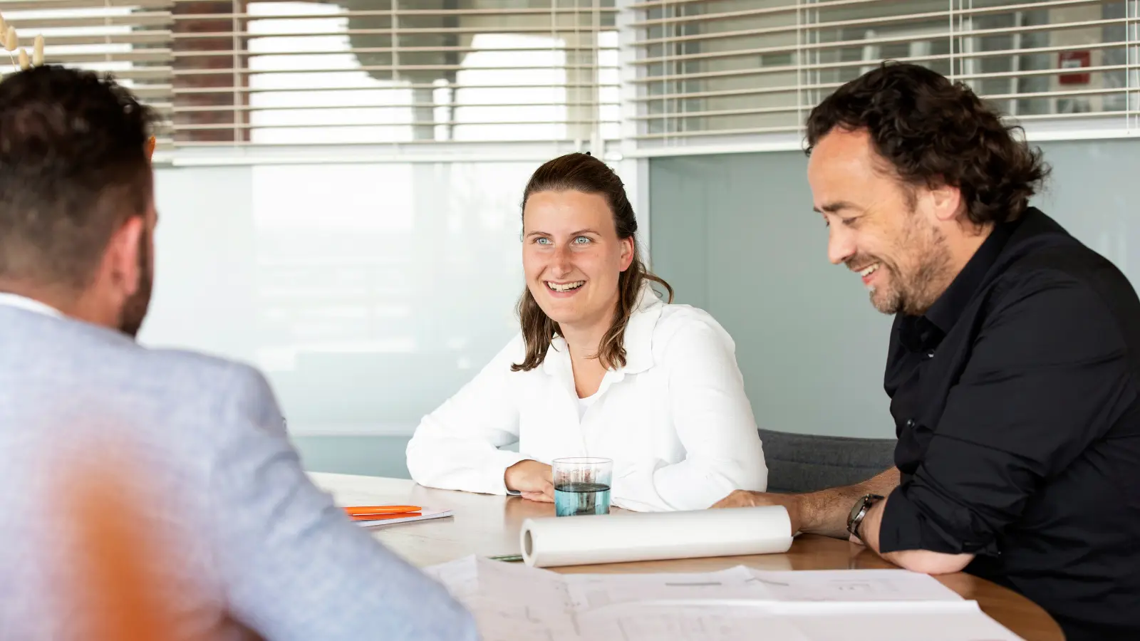 Adviseurs zitten aan tafel een gesprek te voeren