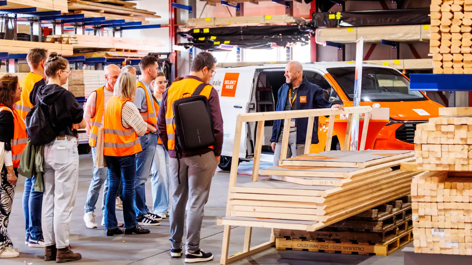 Een groep mensen wordt rondgeleid in een timmerfabriek