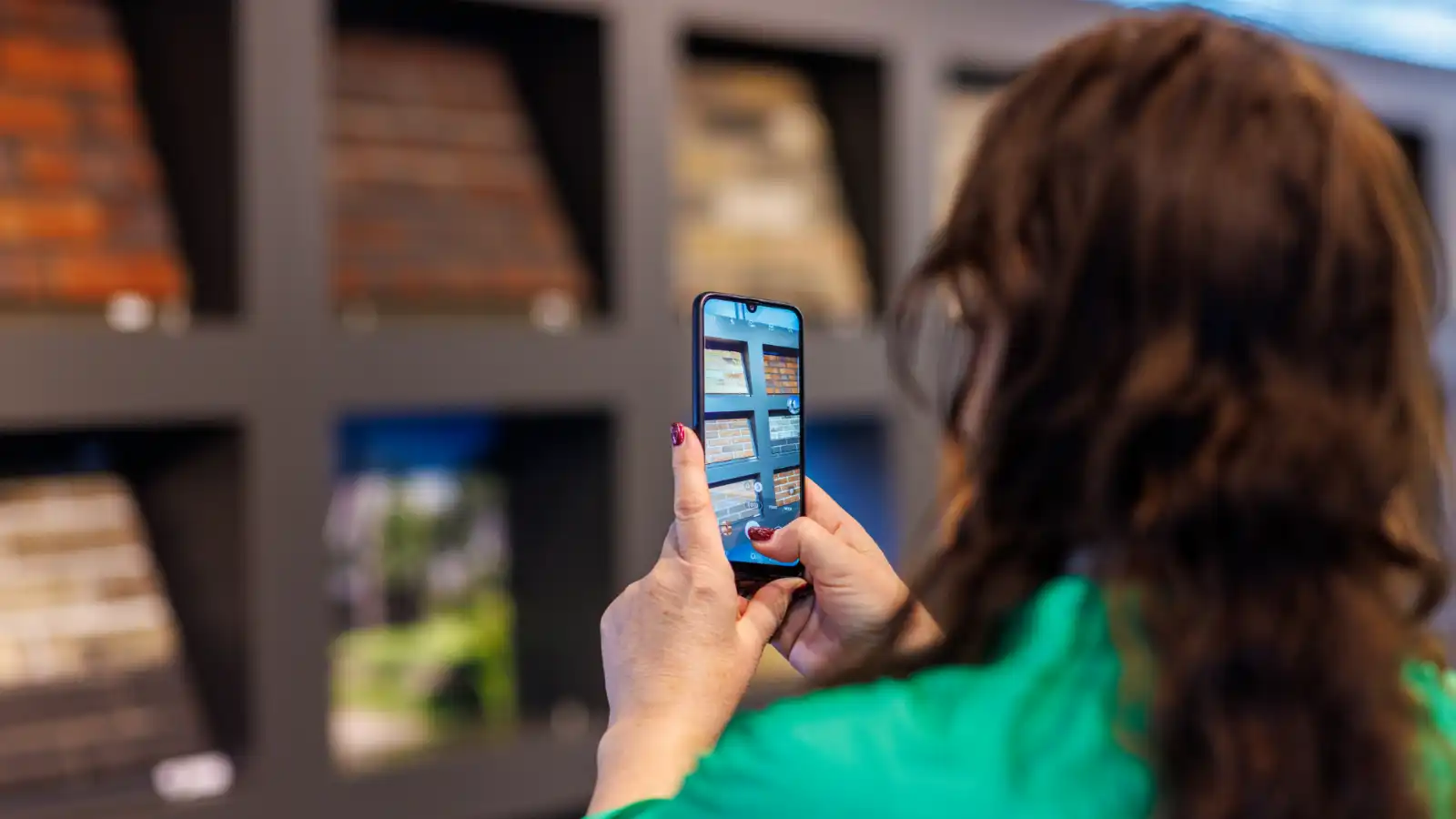 Een vrouw maakt met haar telefoon een afbeelding van diverse gevelstenen