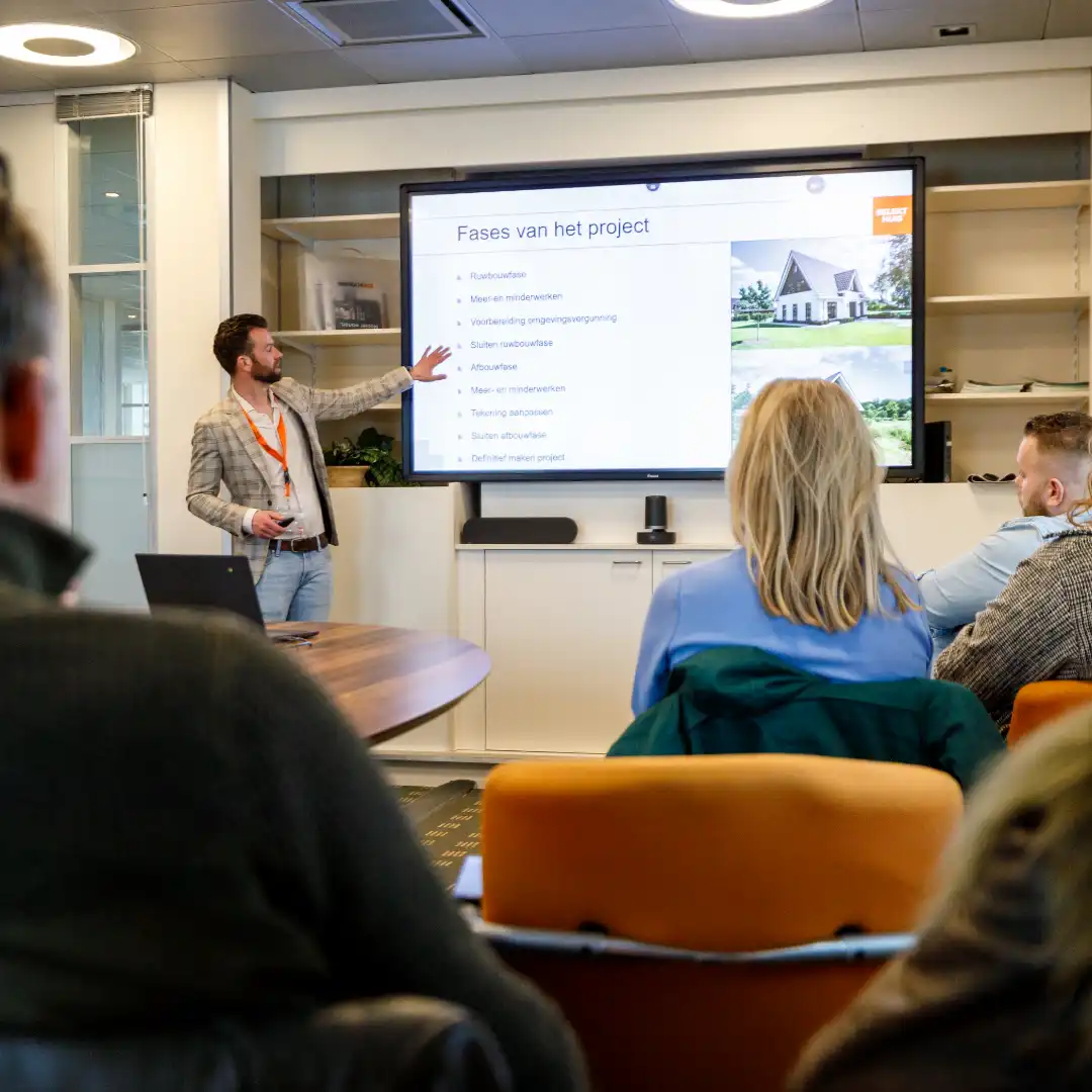 Iemand geeft een presentatie bij een groot beeldscherm