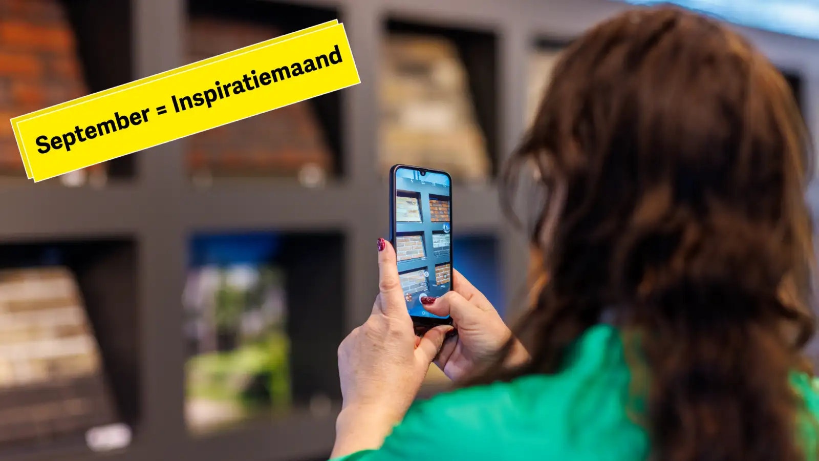 Een vrouw maakt met haar telefoon een afbeelding van diverse gevelstenen