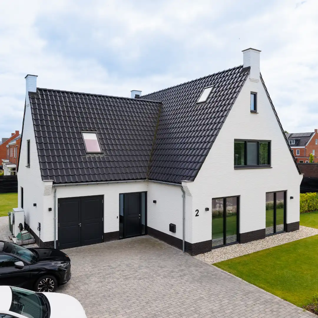 Vooraanzicht van een witte woning met aanbouw