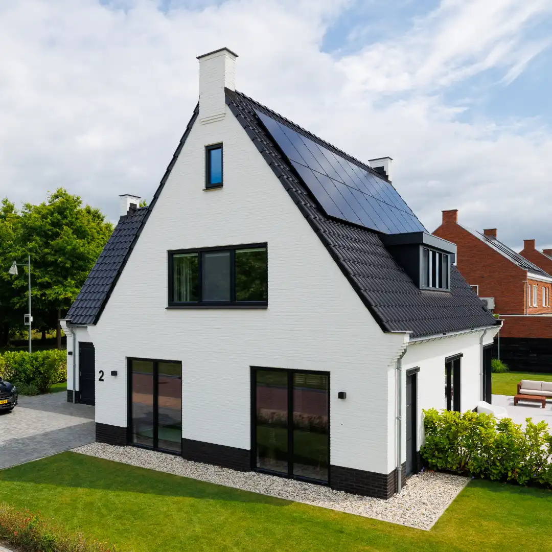 Vooraanzicht van een witte woning met schijnschoorstenen