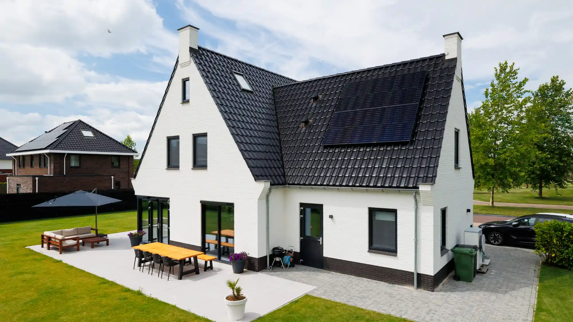 Achteraanzicht witte woning met aanbouw