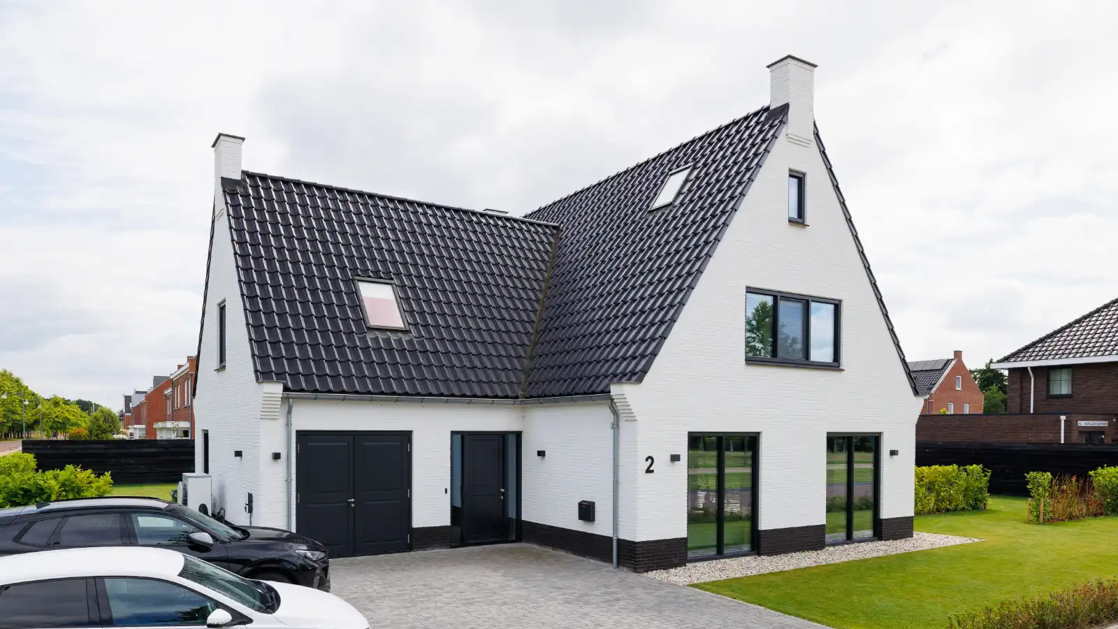 Vooraanzicht van een witte woning met aanbouw