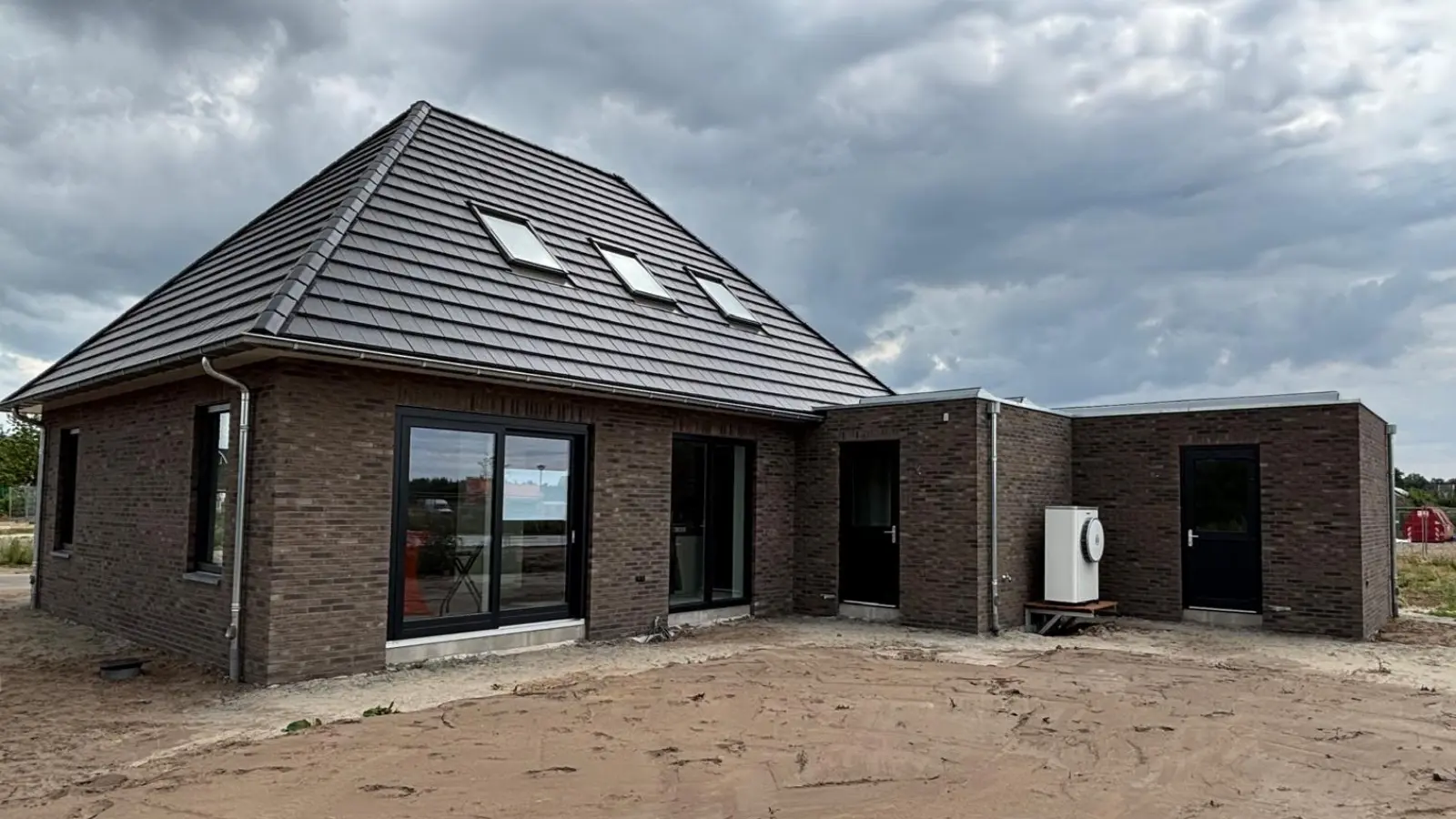 Achteraanzicht van een zwarte notariswoning met aanbouw