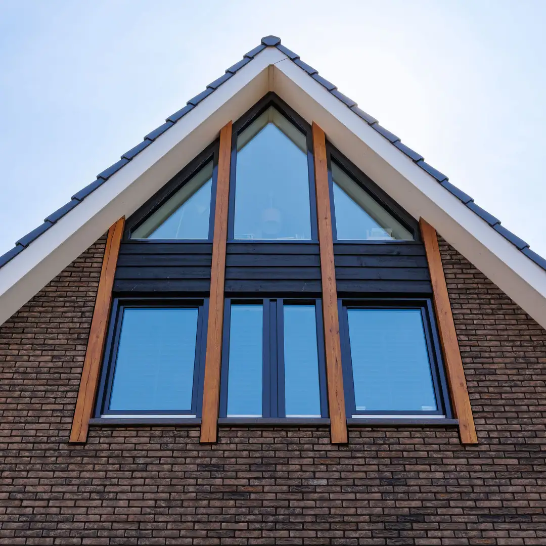 Detailfoto van een topgevel met glas en houten balken